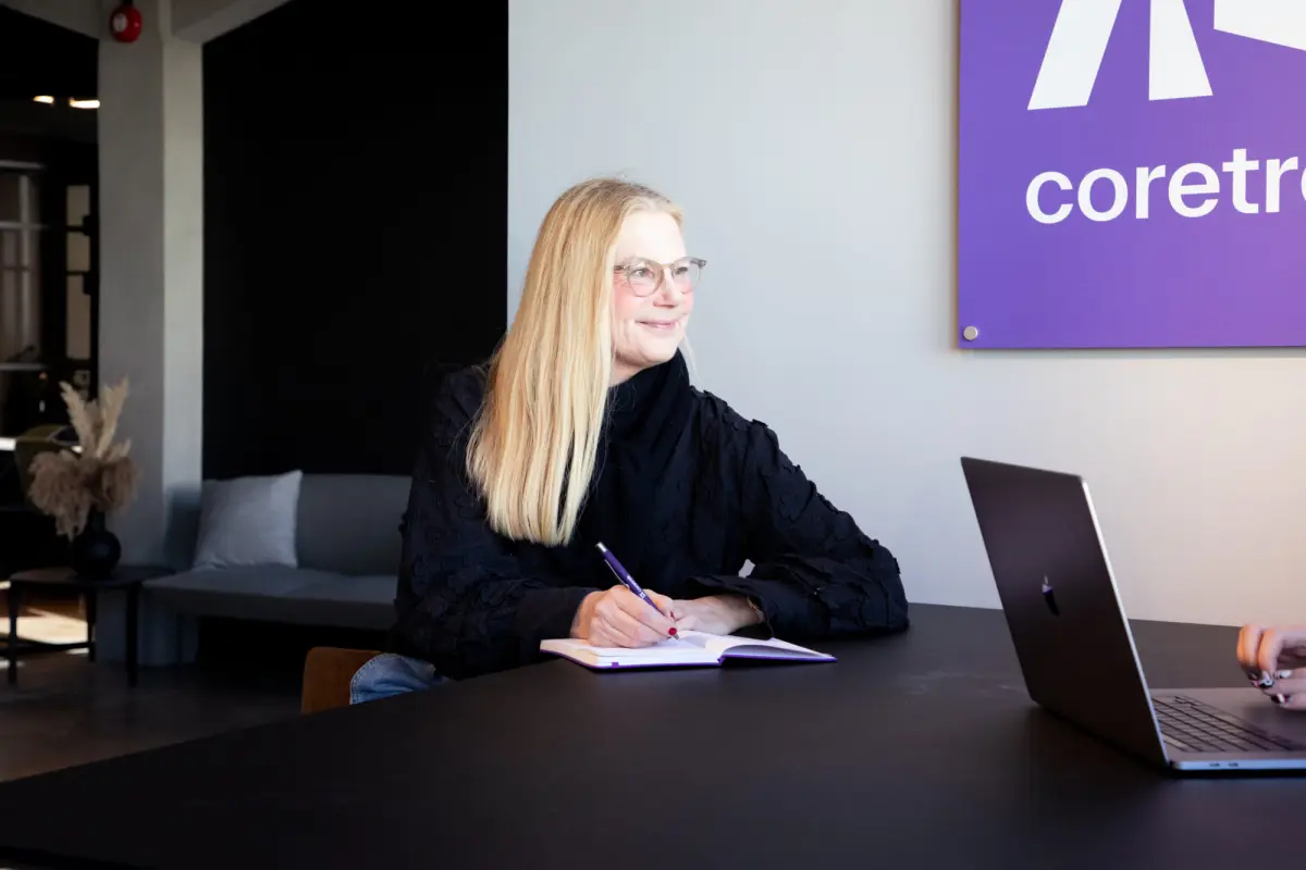 Kvinne med notatblokk i møte