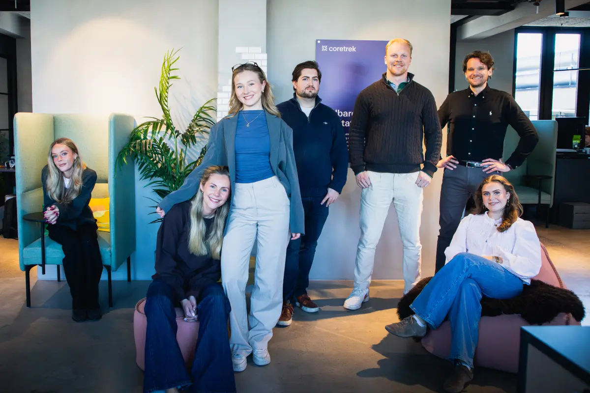 Gruppe personer som står i et kontorlandskap