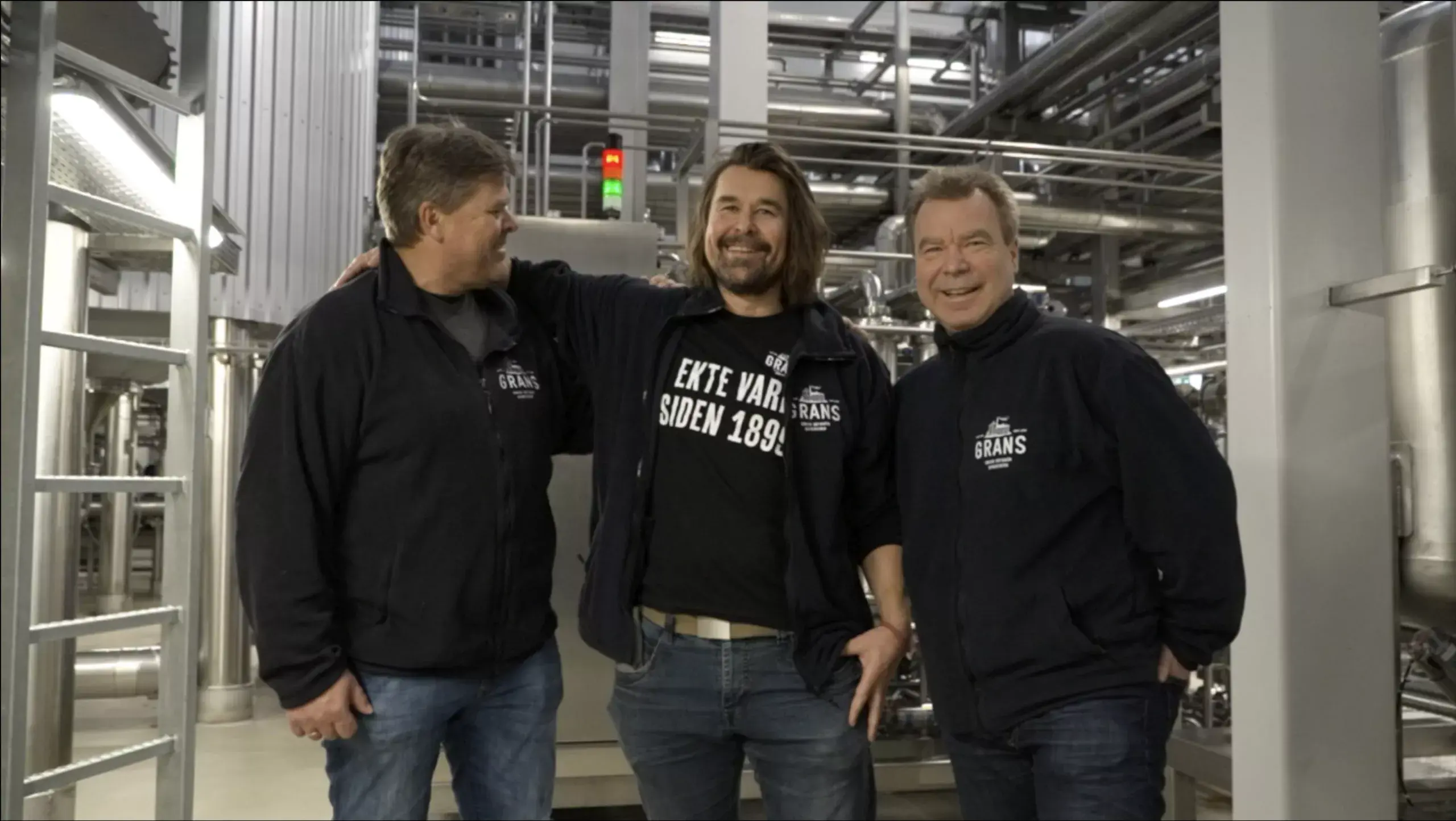 Tre menn i produksjonslokaler til et bryggeri